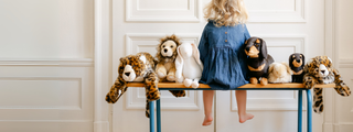 Enfant assise avec des peluches réalistes, parfaites pour une liste de naissance ou un cadeau bébé., luxe, boutique France, La Pelucherie